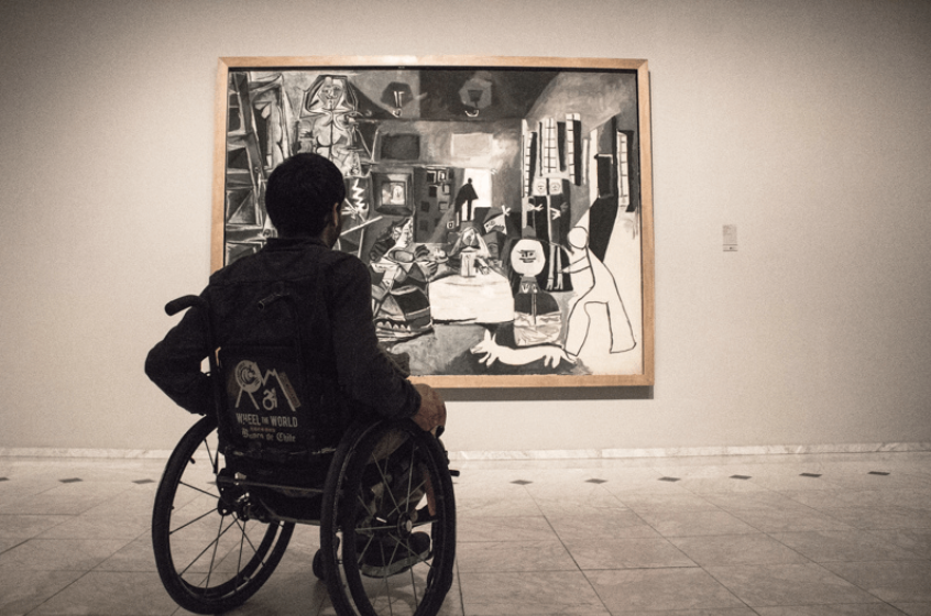 Wheelchair user observing a painting in the Pablo Picasso museum in Barcelona