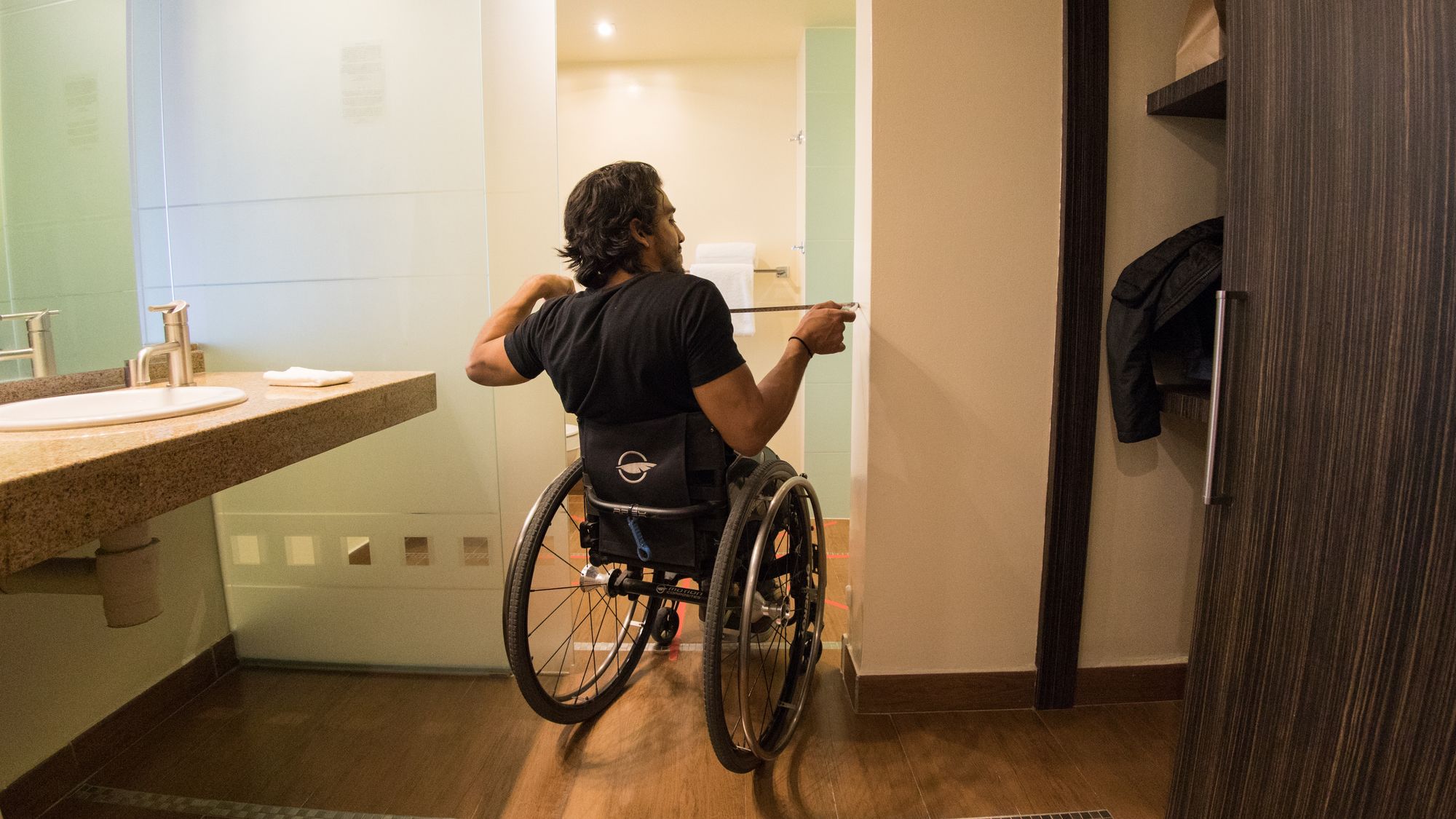 A Wheel the World Mapper taking measurements of the hotel bathroom to ensure accessibility