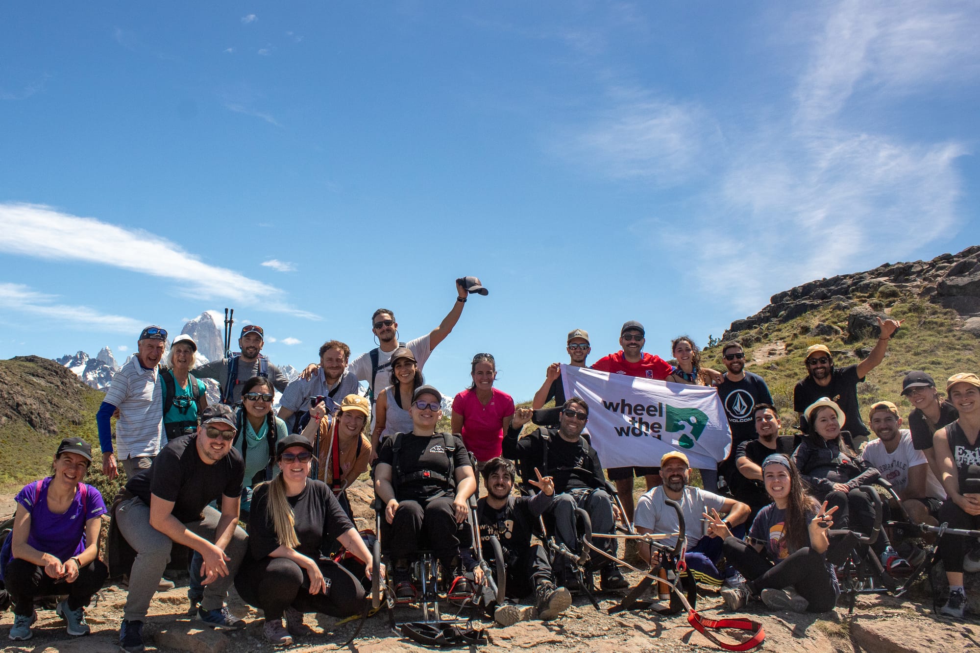 Group photo of the Wheel the World team hiking in Patagonia. Wheelchair users in joelette wheelchairs