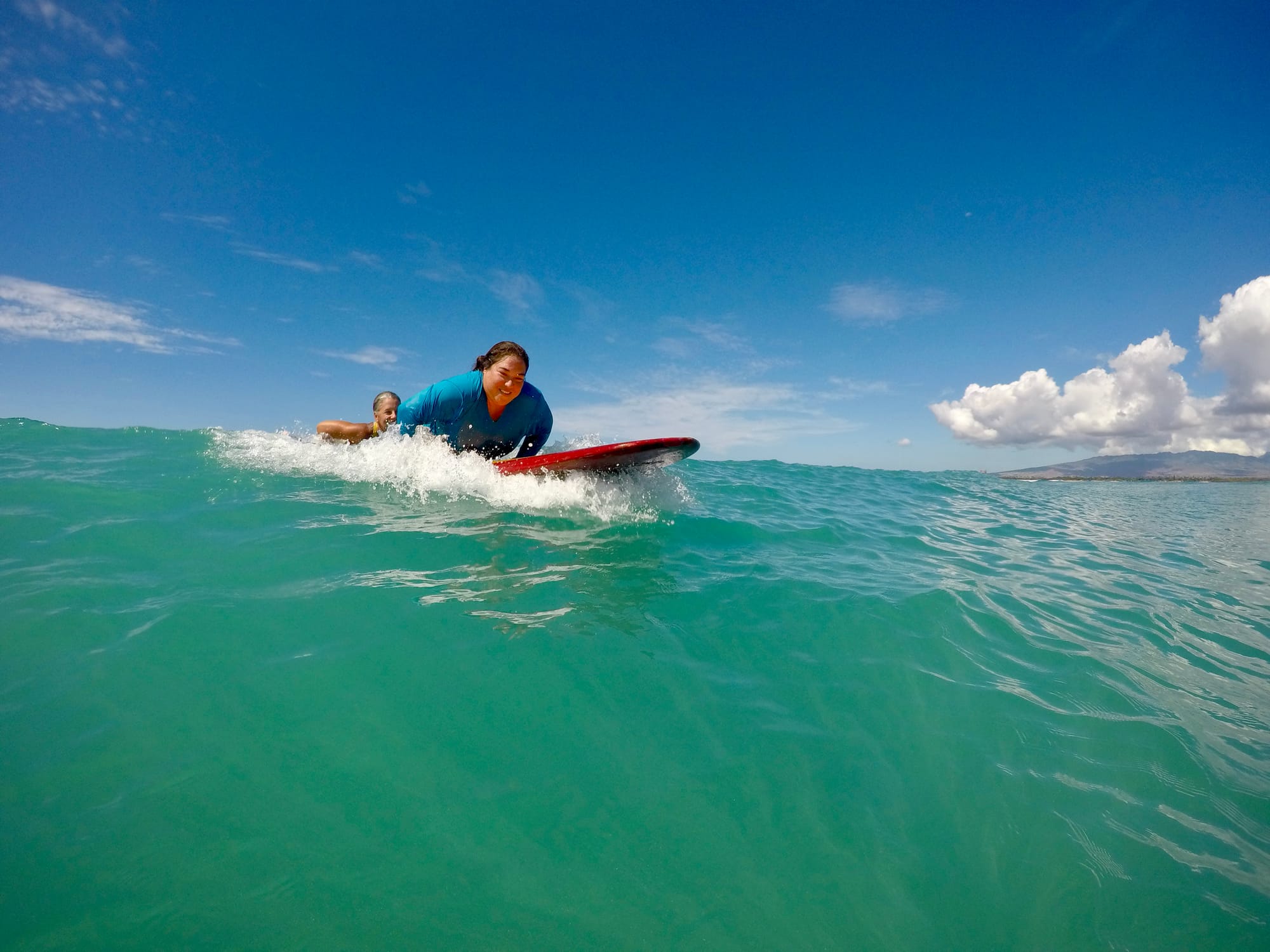 Wheelchair user riding a wave with an adaptive surfing lesson