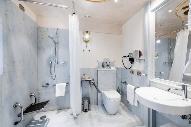Accessible bathroom at the Monaco & Grand Canal hotel in Venice. Roll-in shower and toilet grab bars