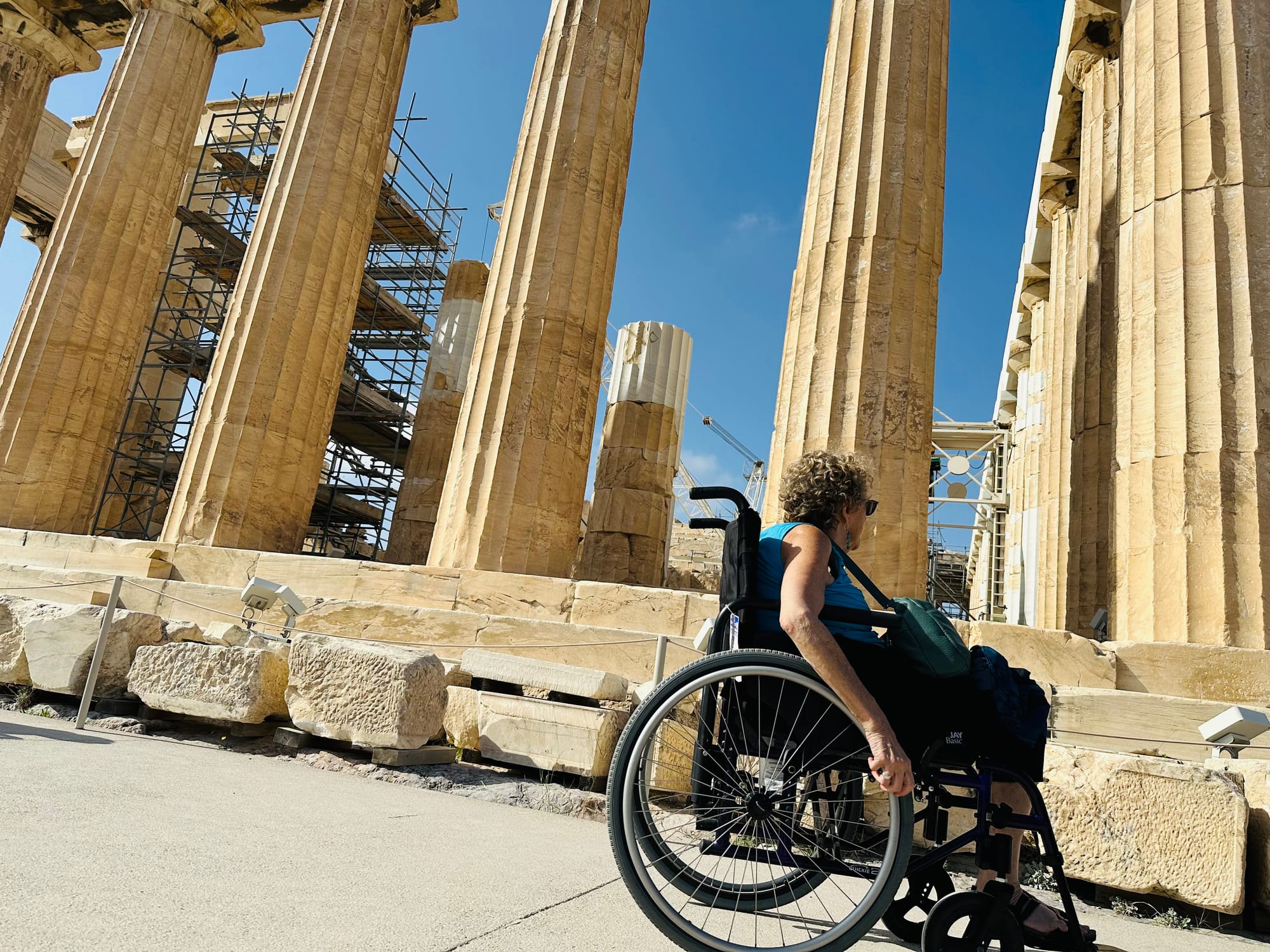 Wheelchair-user exploring the Temple of Olympian Zeus in Athens. An accessible attraction