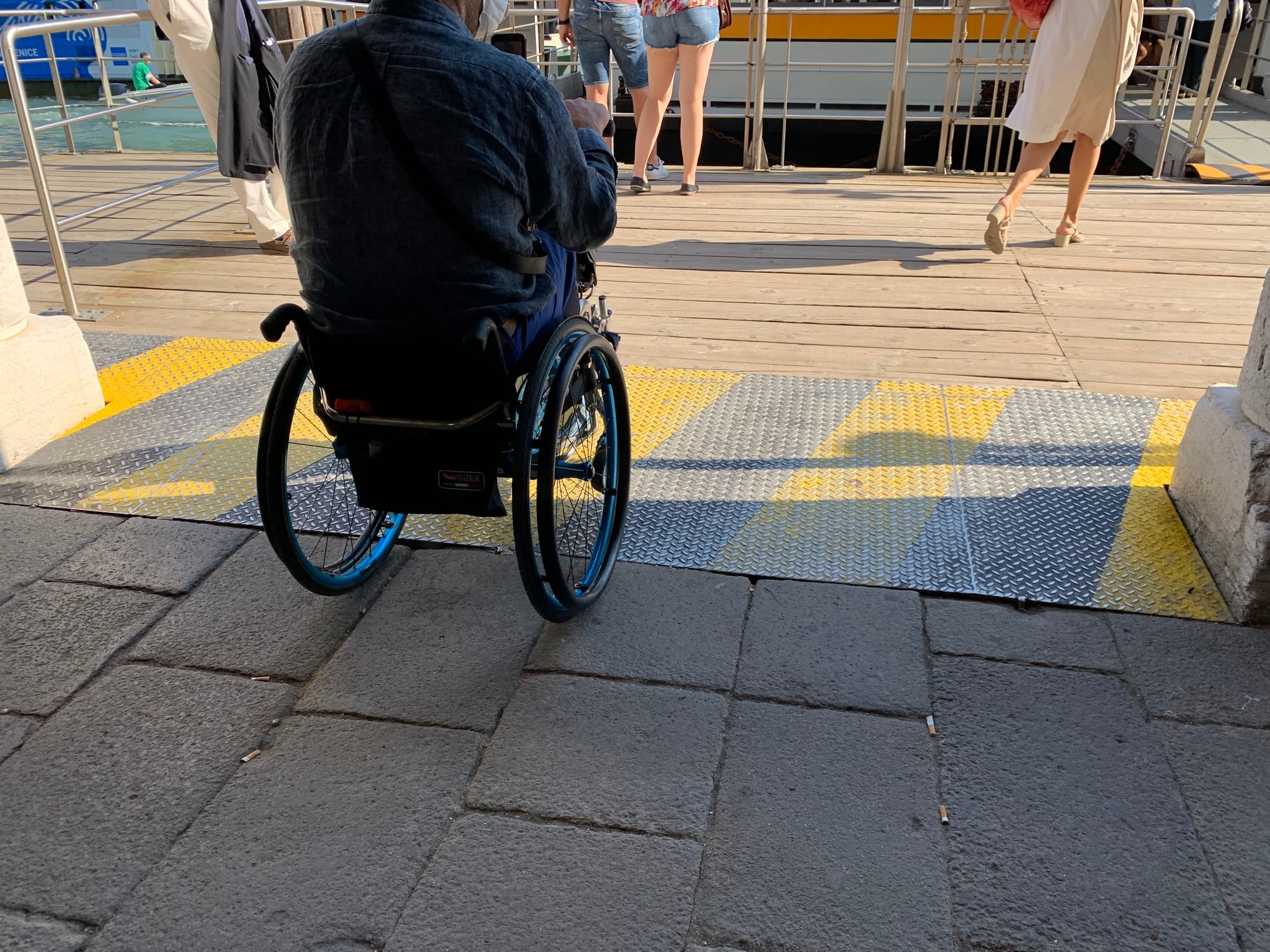 Wheelchair-user going over an accessible pathway in Venice, Italy