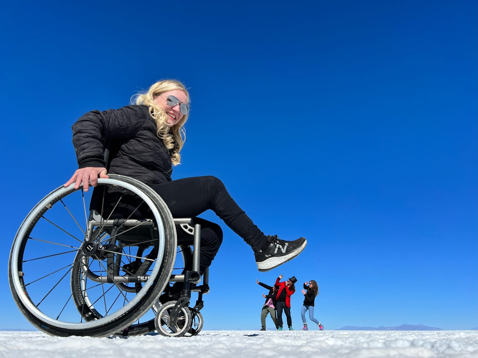 Wheelchair user posing with people at the Uyuni Salt Flat in Bolivia