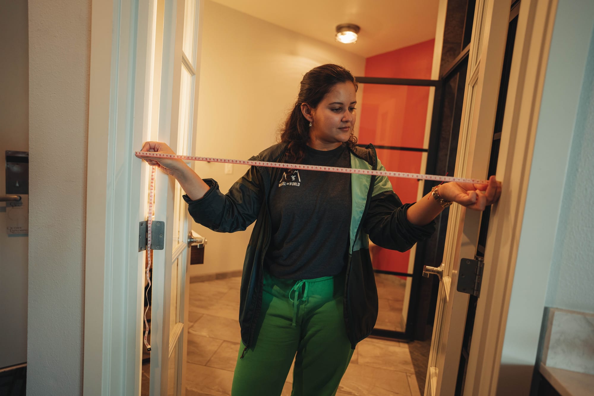 Mapper measuring the bedroom door width in a hotel to ensure detailed and accurate accessibility information