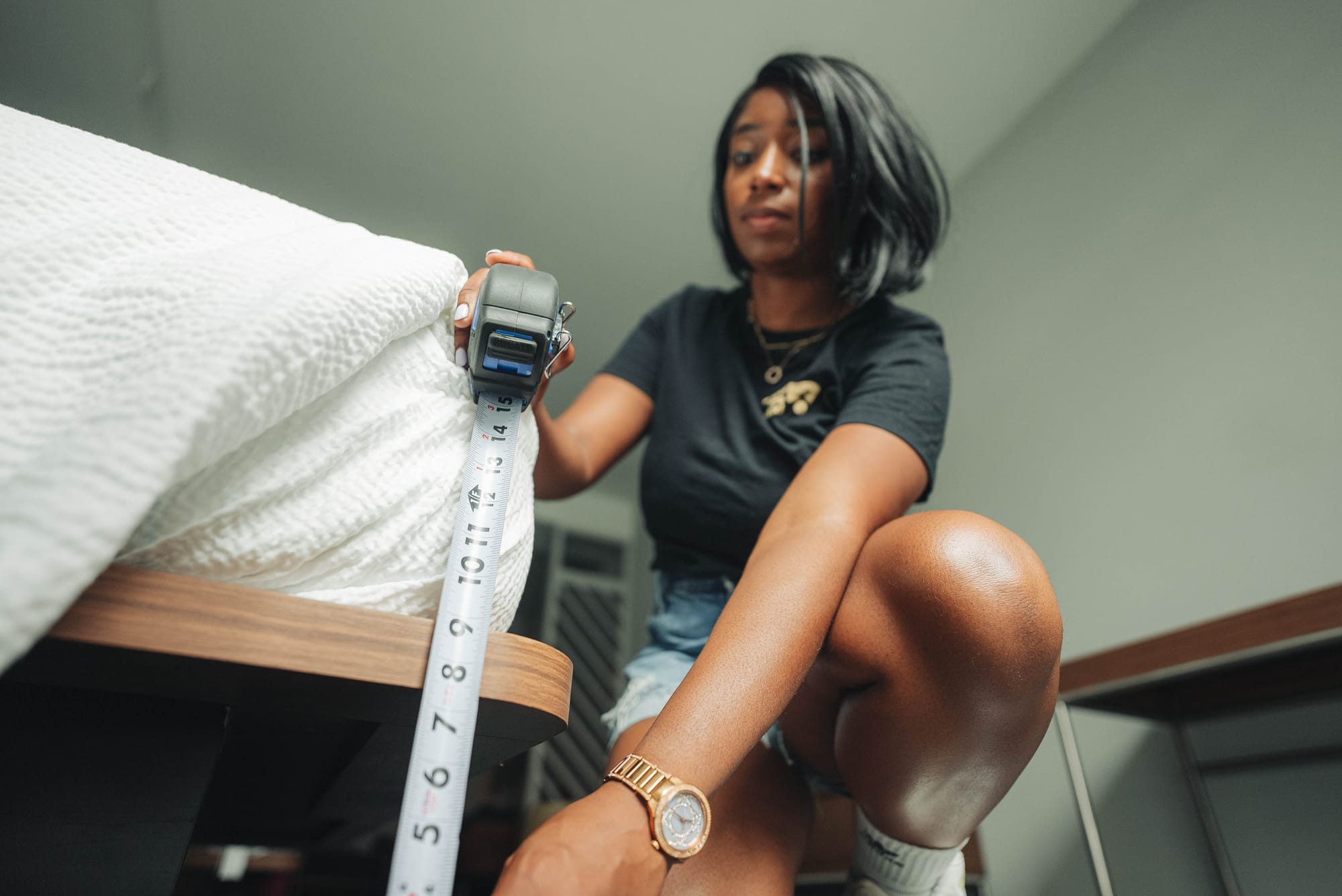 Woman measuring the bed height in a hotel to ensure accurate and reliable accessibility information