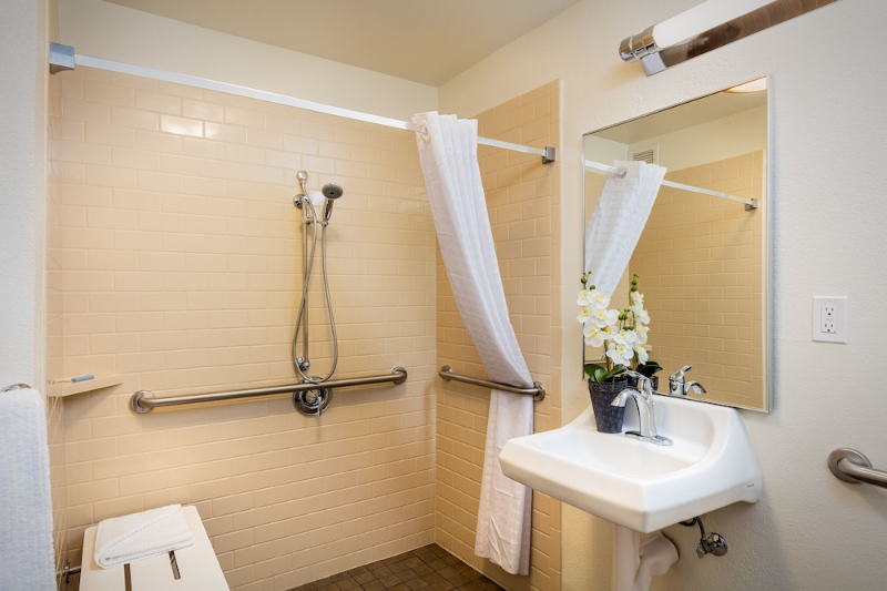 Candlewood Suites Anaheim featuring a room with a roll-in shower, shower bench, and grab bars