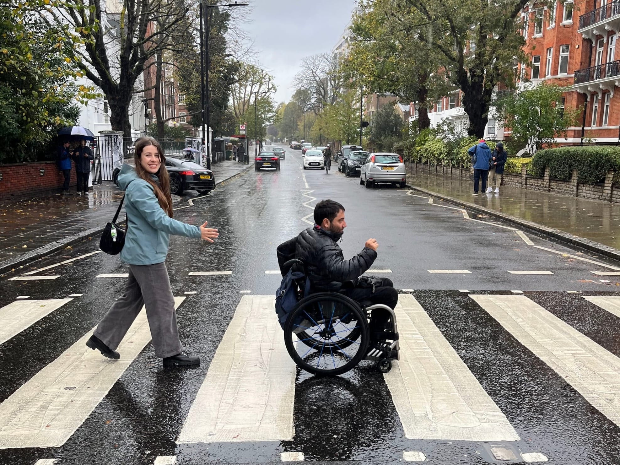 Wheelchair-user and companion crossing the street in London, England