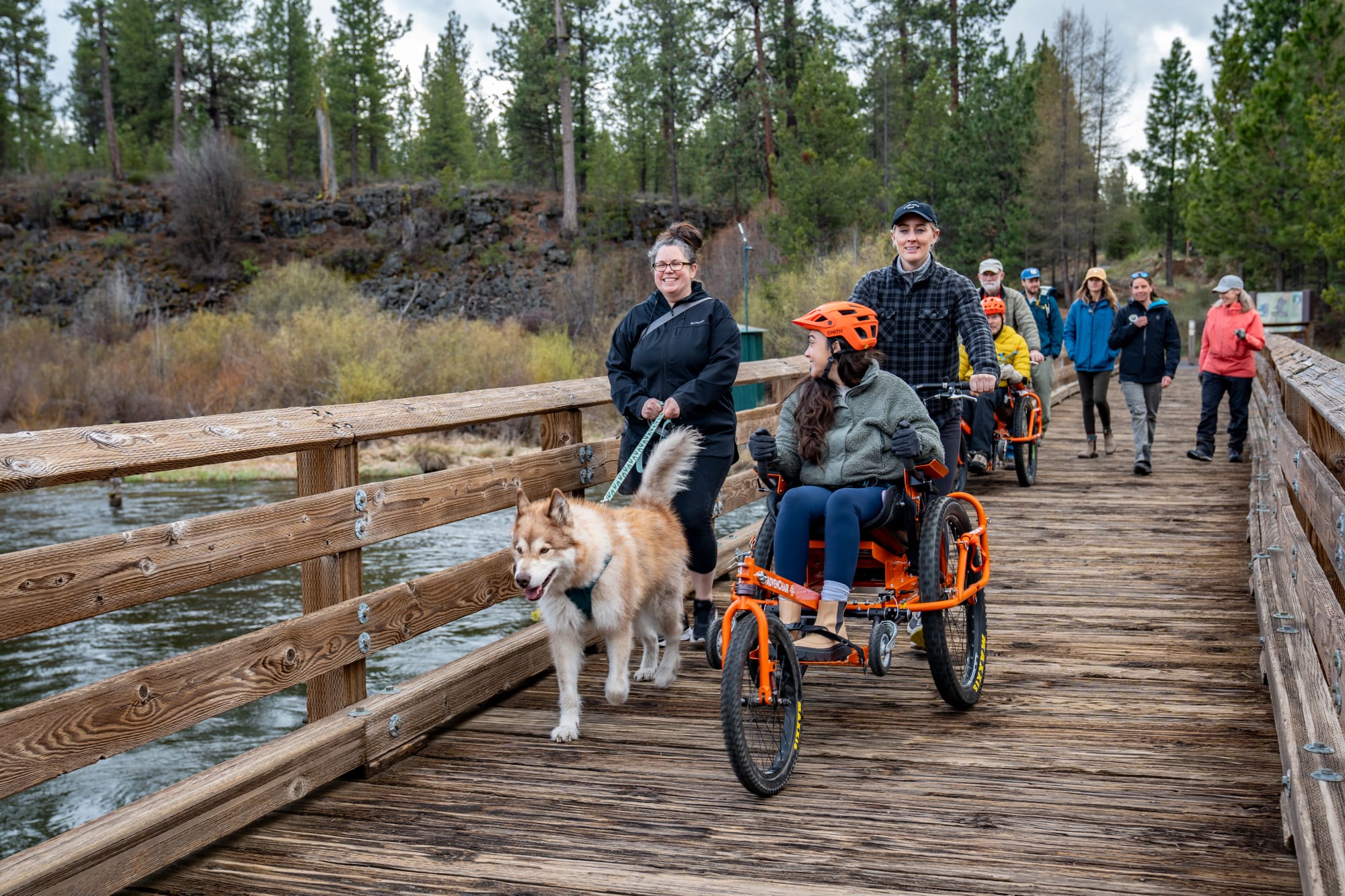 Wheelchair user and friends crossing the river via bridge