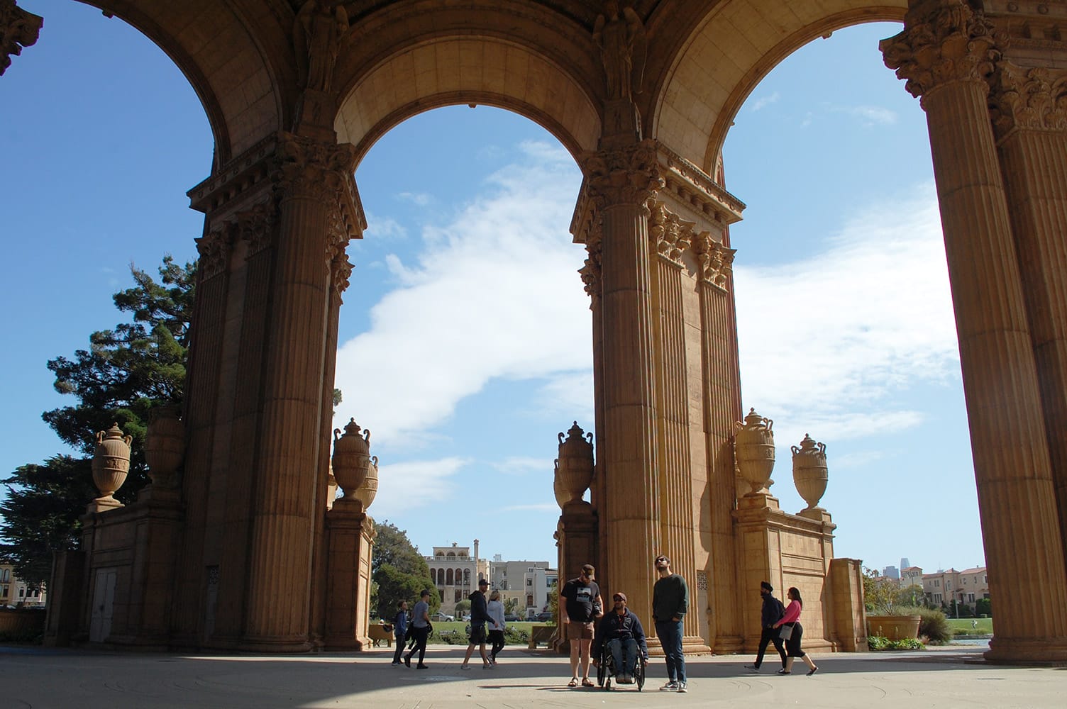 Wheelchair-user poses with friends under Palace of Fine Arts in San Francisco