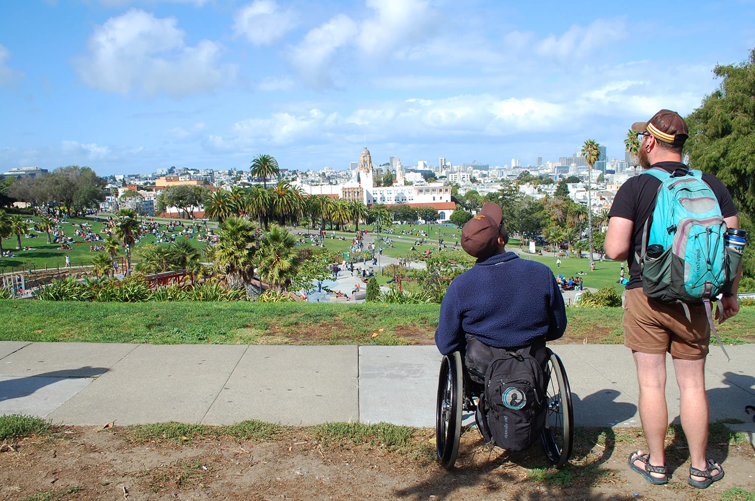 Wheelchair user and companion enjoying views of Dolores Park in San Francisco