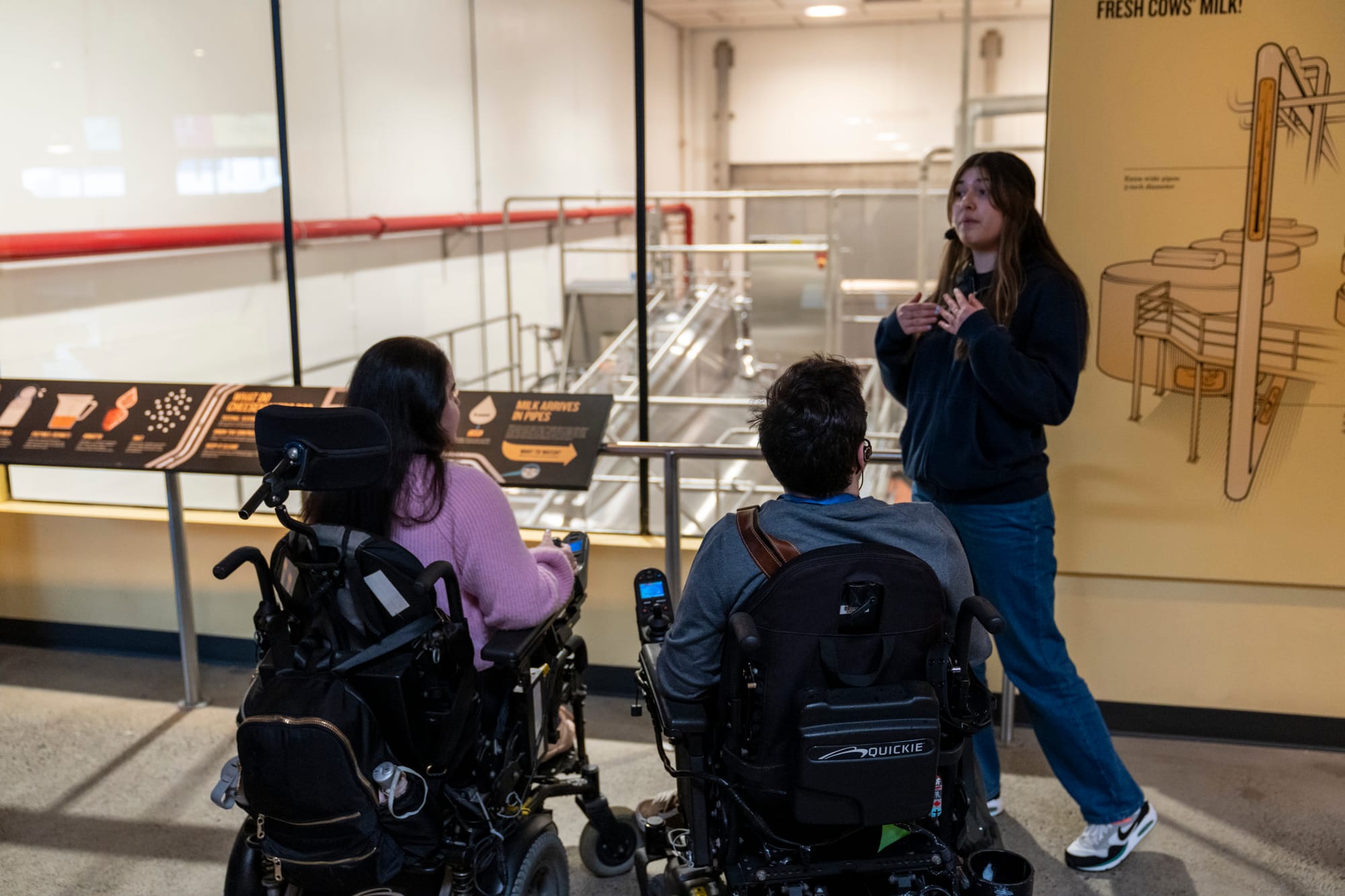 Two wheelchair-users enjoying a guided tour of the Tillamook Creamery