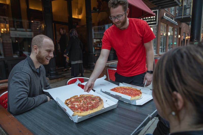 People enjoying pizza at Lou Malnati's Pizzeria in Chicago