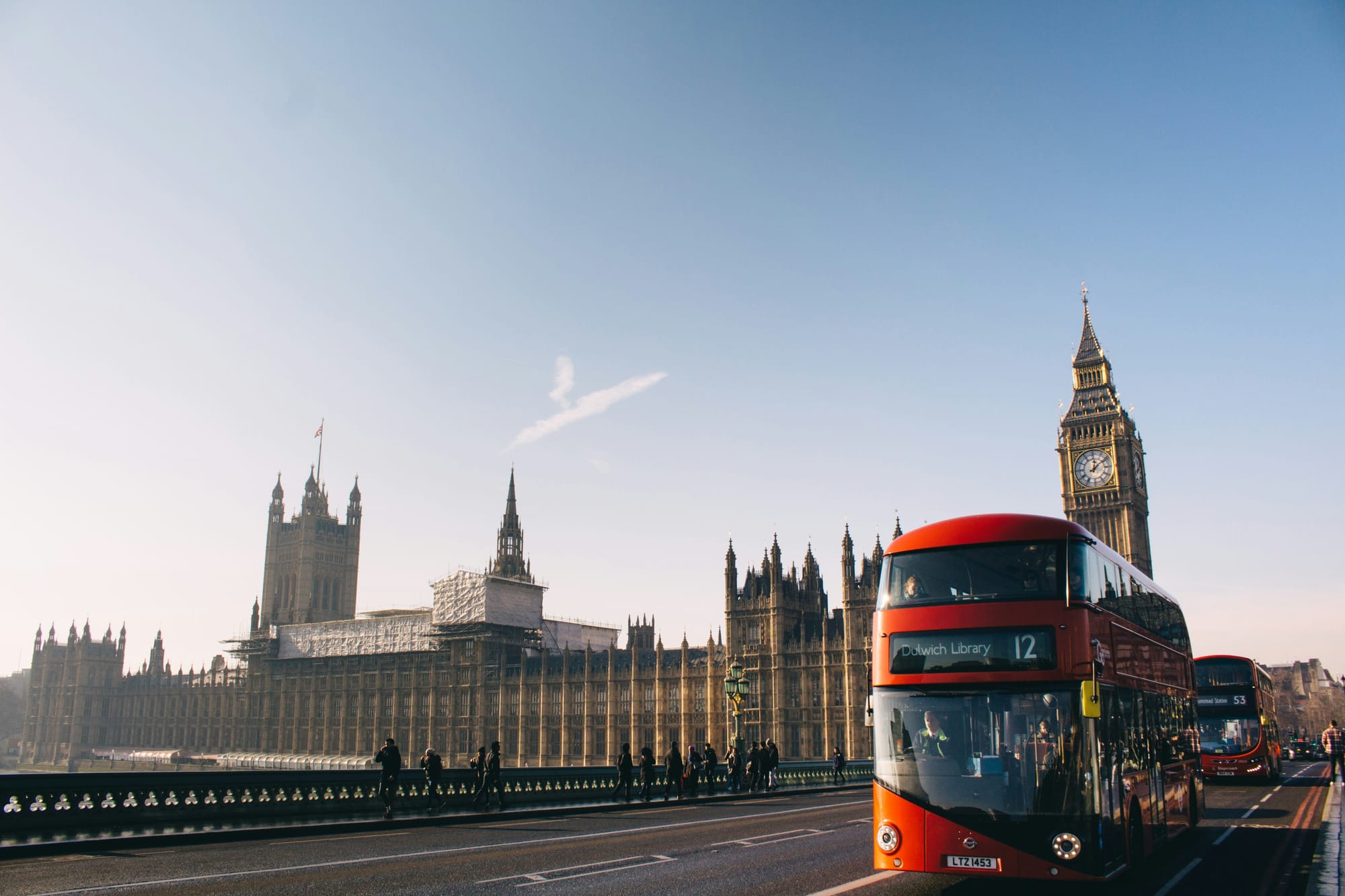 Red bus in London passing by Big Ben