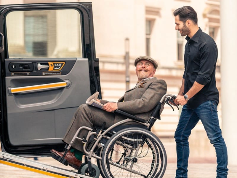 Wheelchair-user loading up into an adaptive van with a wheelchair ramp in London