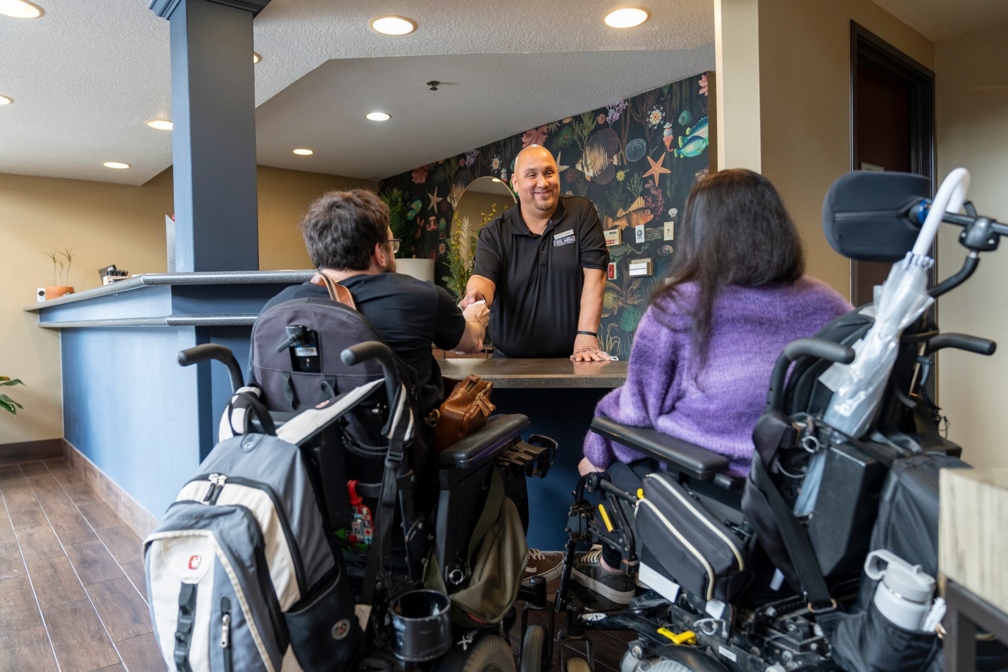 Wheelchair users receiving exceptional service at an accessible hotel