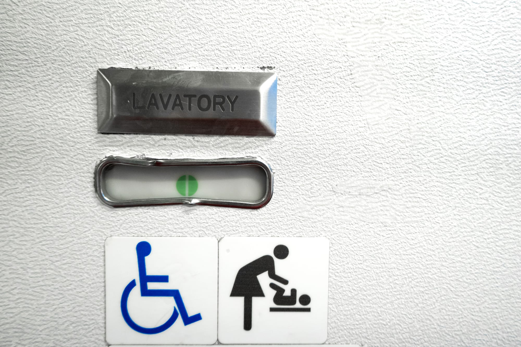 Airplane lavatory with wheelchair sign that means its equipped for people with disabilities