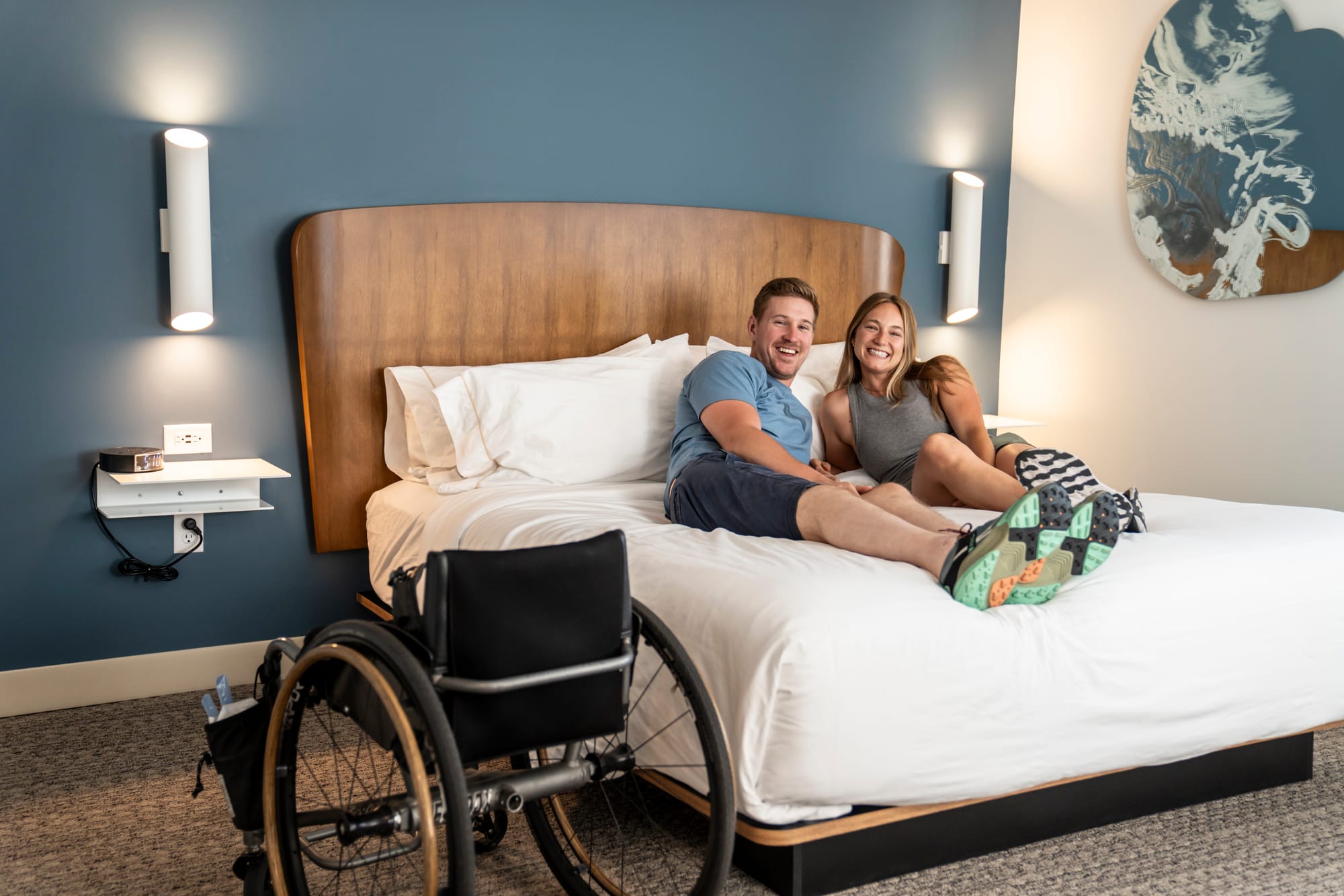 Wheelchair-user and partner enjoying their accessible room booked through Wheel the World