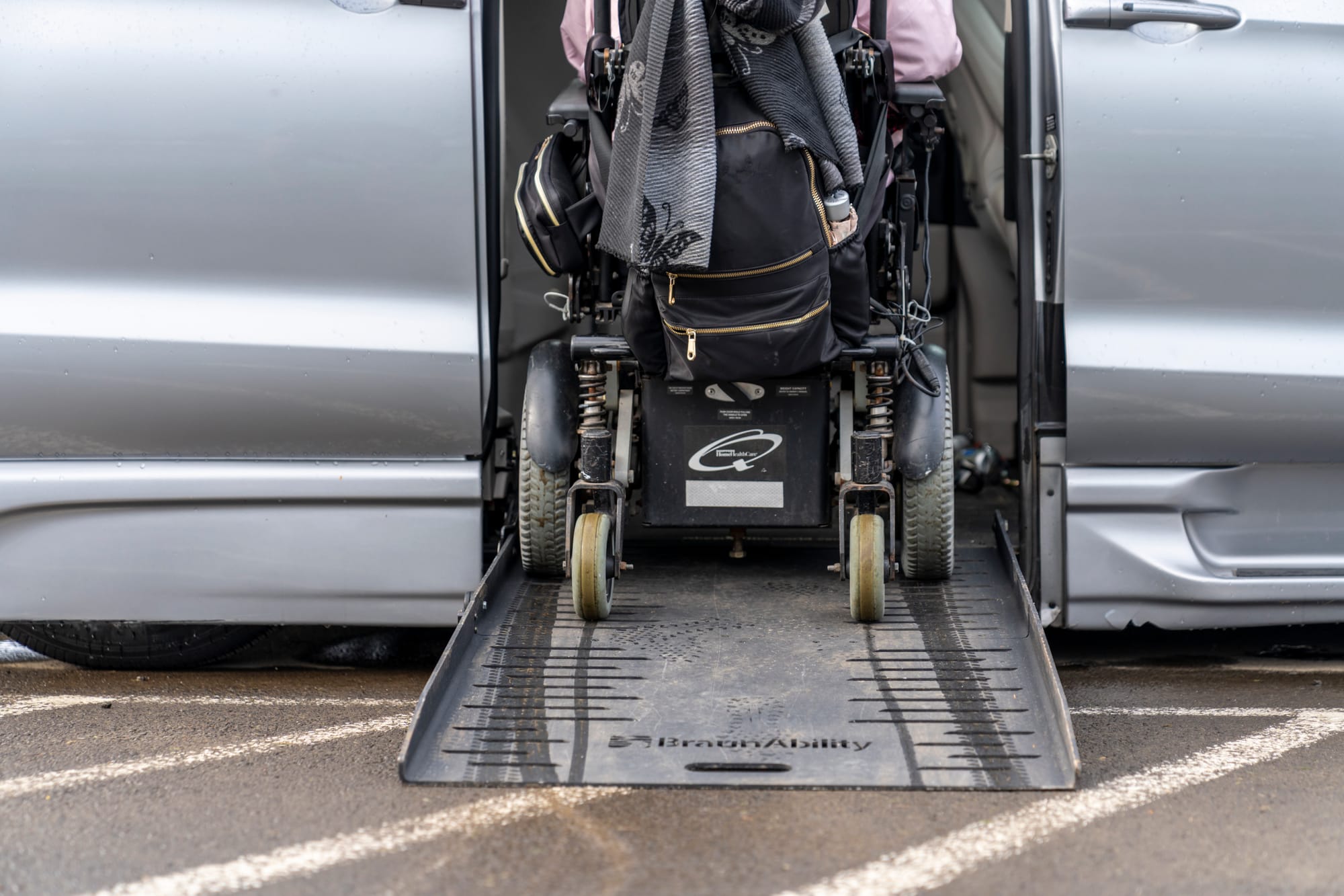 Wheelchair user entering adapted van via wheelchair ramp.