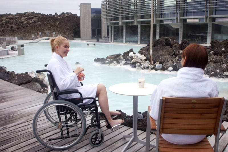 Wheelchair user and companion sipping drinks while at the blue Lagoon