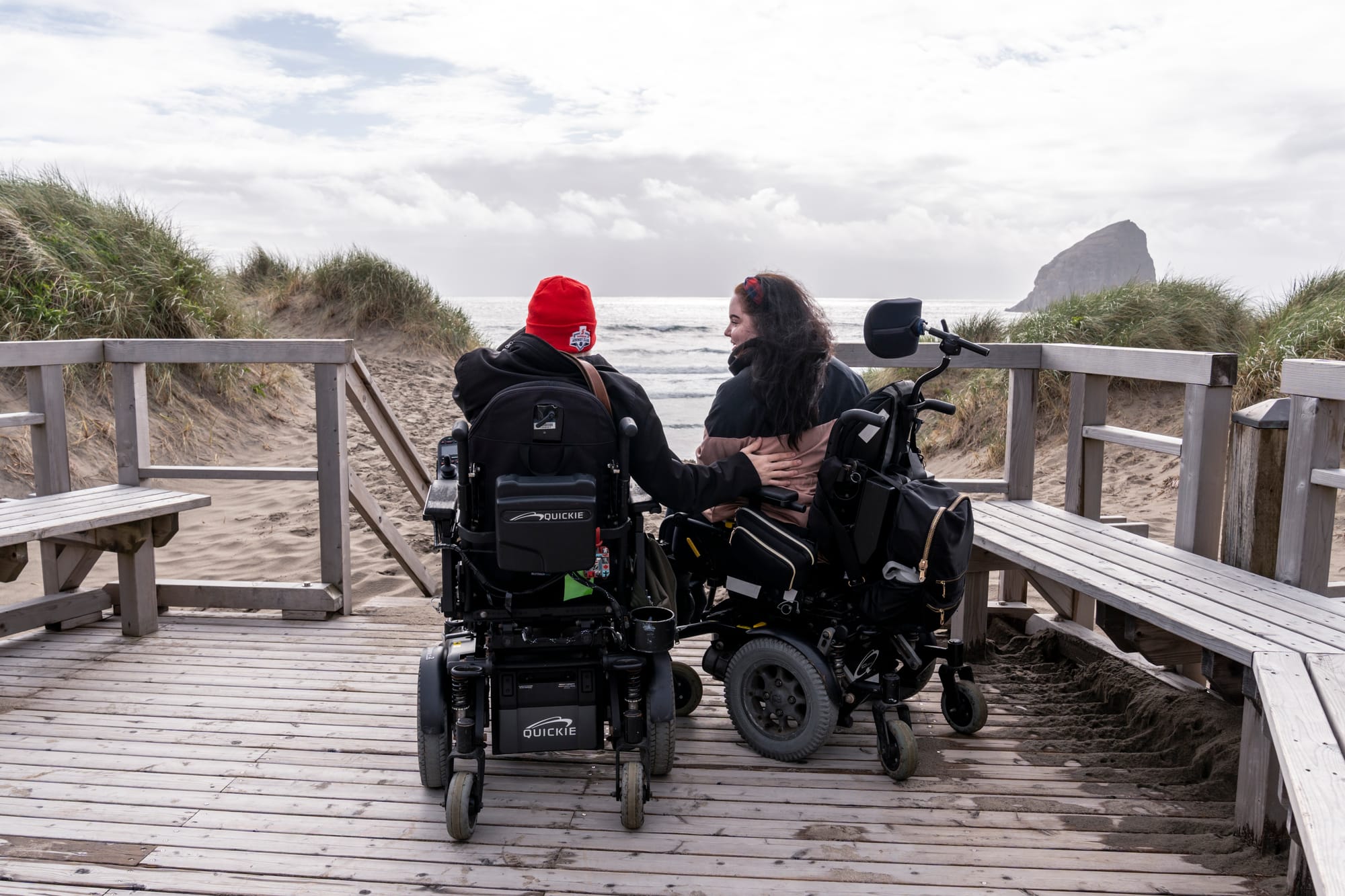 Two wheelchair-users enjoying ocean views in Cannon Beach, Oregon