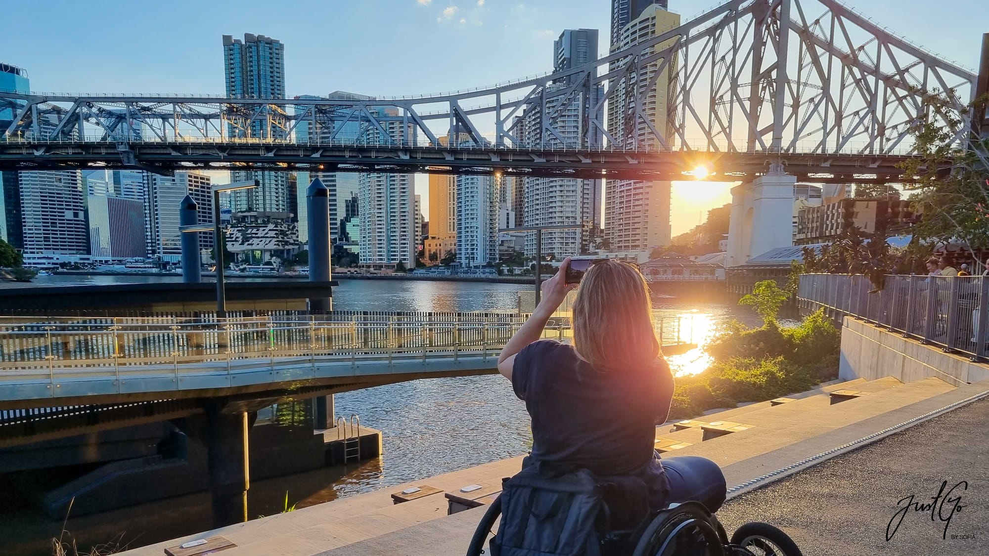 Wheelchair user taking a photo of a bridge in Sydney, Australia