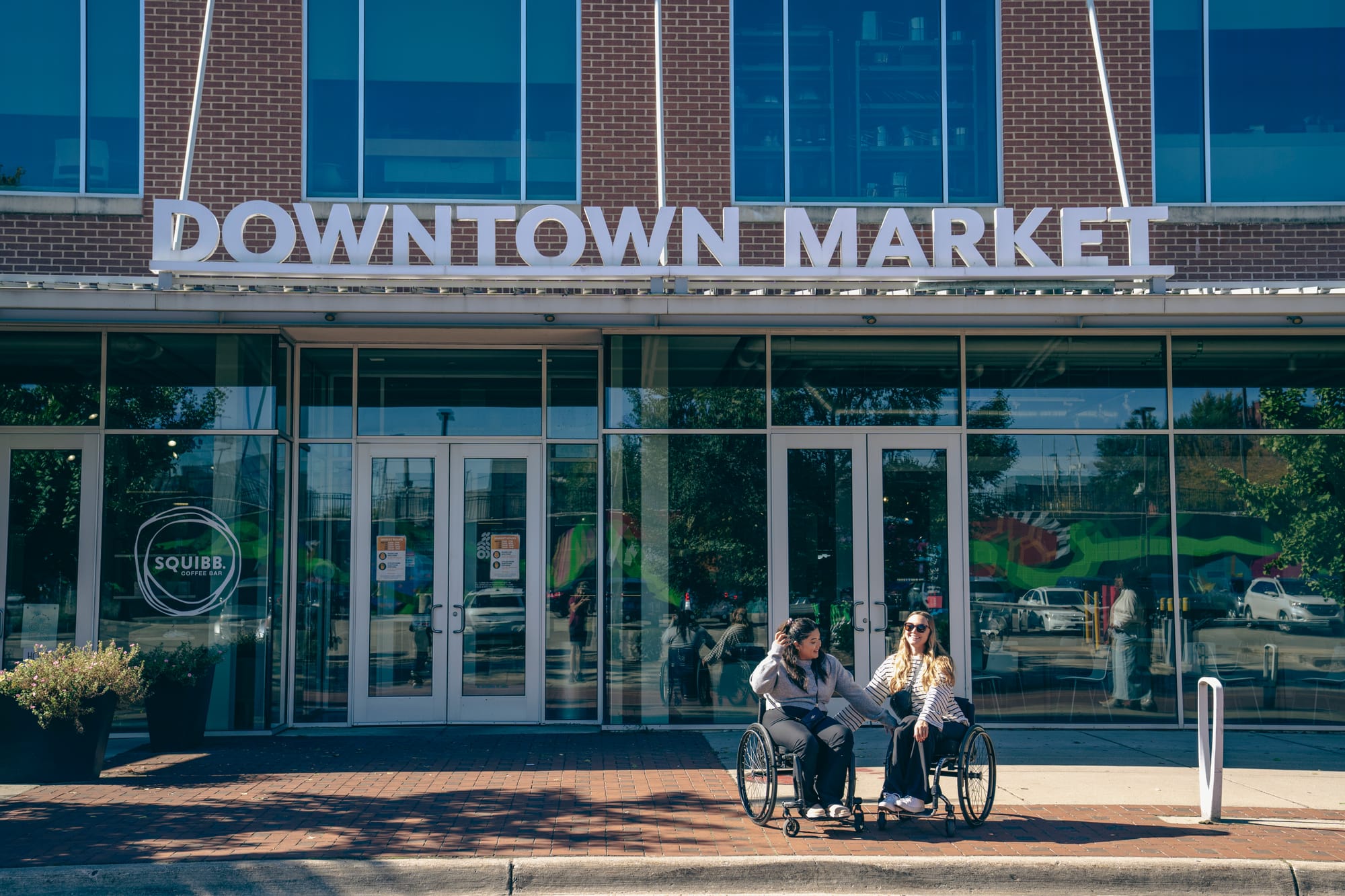 Wheelchair-users outside of the Downtown Market in Grand Rapids