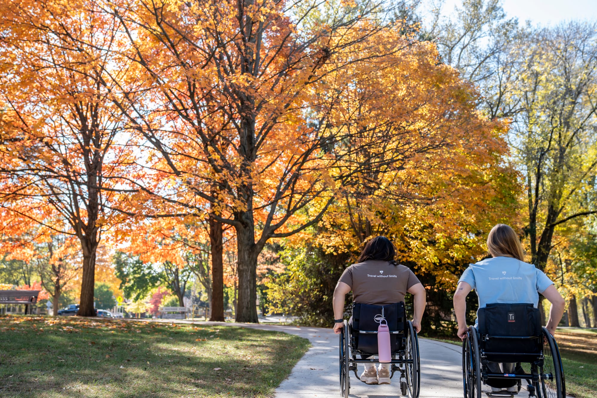 Two wheelchair-users exploring accessible park trails in Grand Rapids