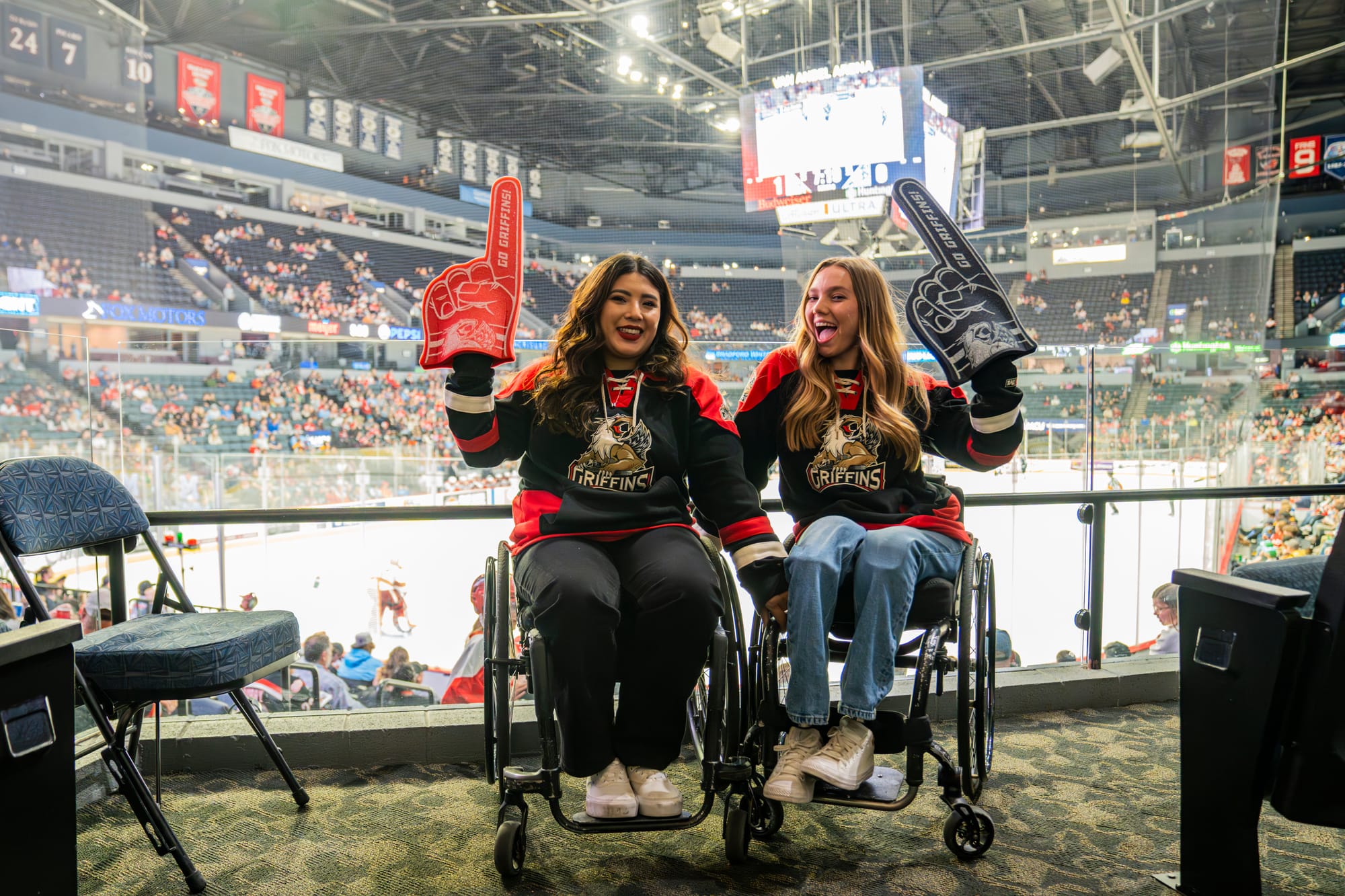 Two wheelchair users cheering on the Grand Rapids Griffins