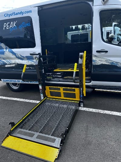 A wheelchair lift connected to a Mt. Hood Express van
