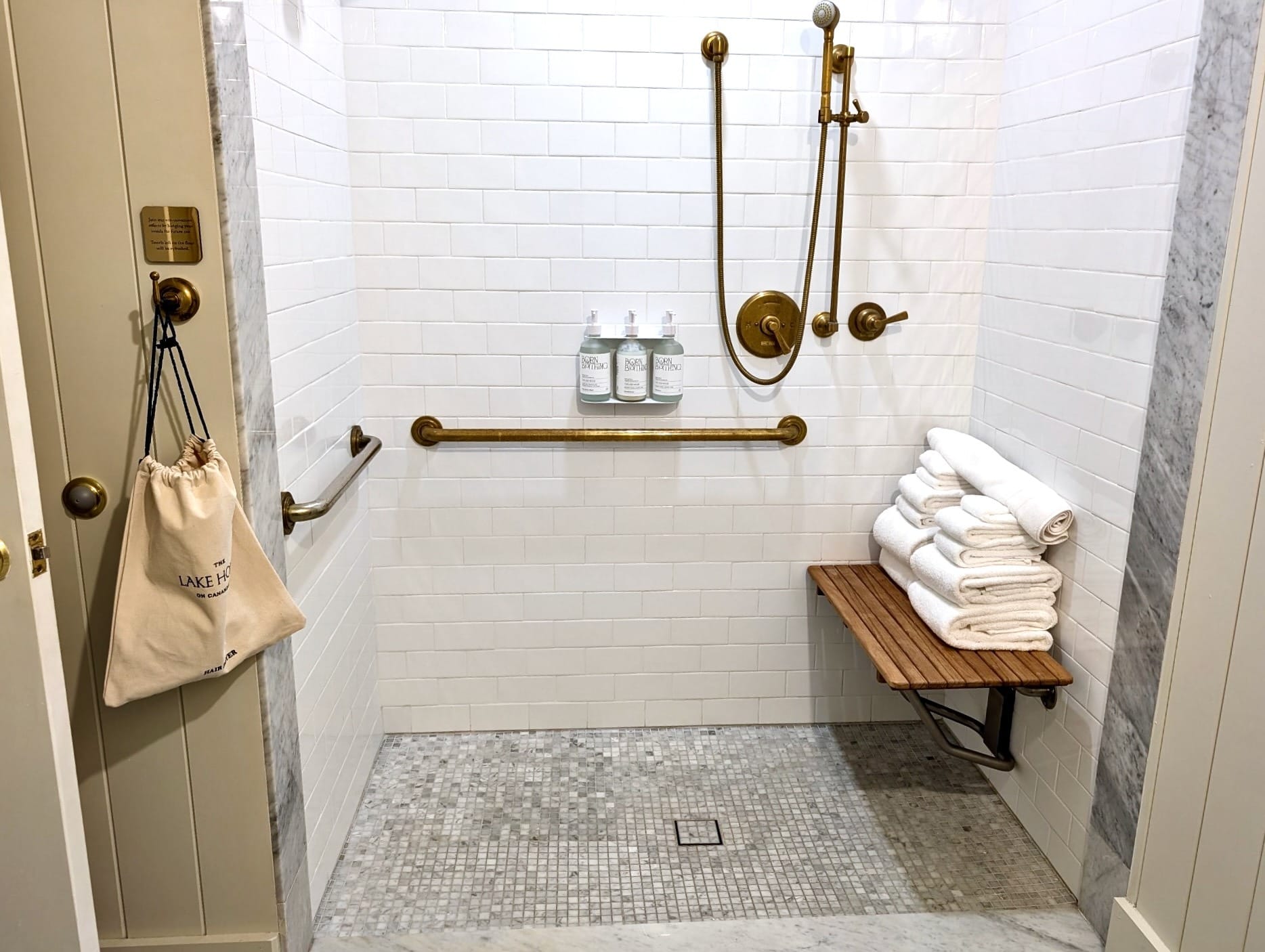 Roll-in shower with bench, grab bars, and handheld showerhead