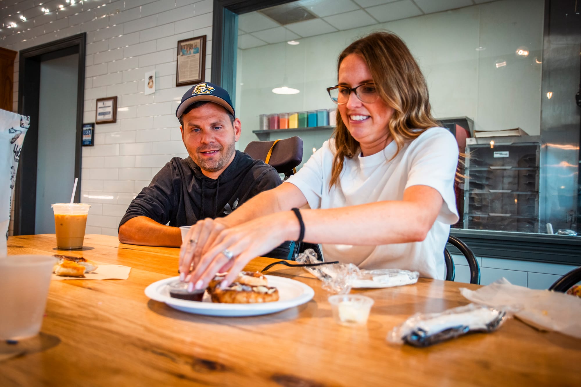 Woman and her husband, a wheelchair user, digging into donuts on the Donut Trail, Butler County