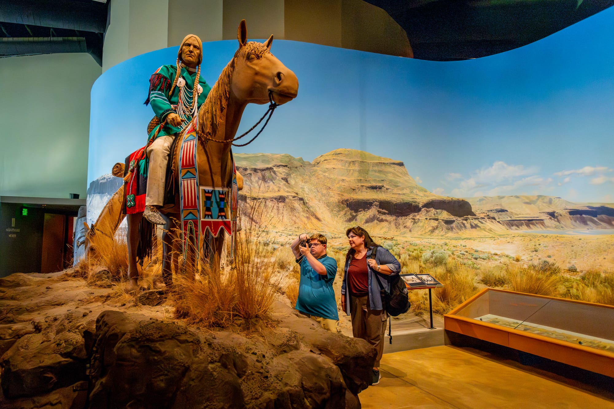Man taking a photo of exhibits at Tamástslikt Cultural Institute