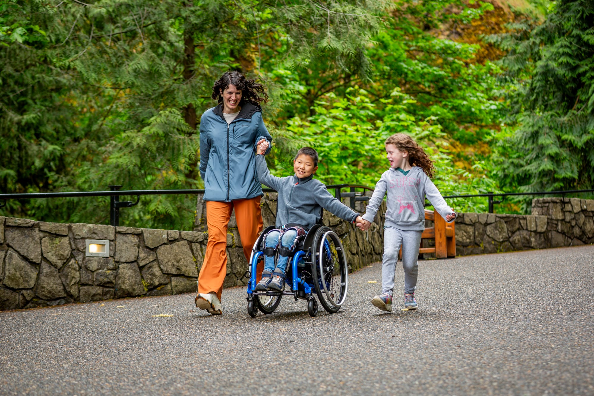 Jaden, a boy and wheelchair user, and his mom and sister enjoying the outdoors along the Gorge