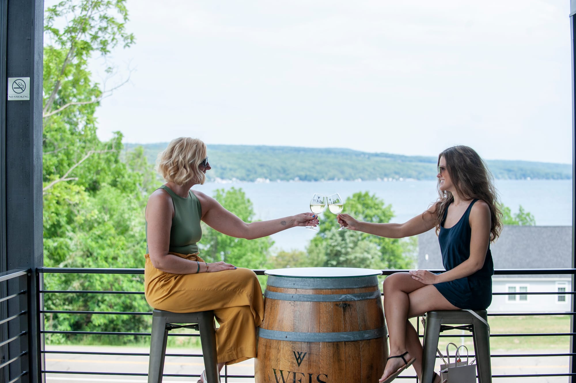 Two women cheering wine glasses at Weis Vineyards in Steuben County, NY