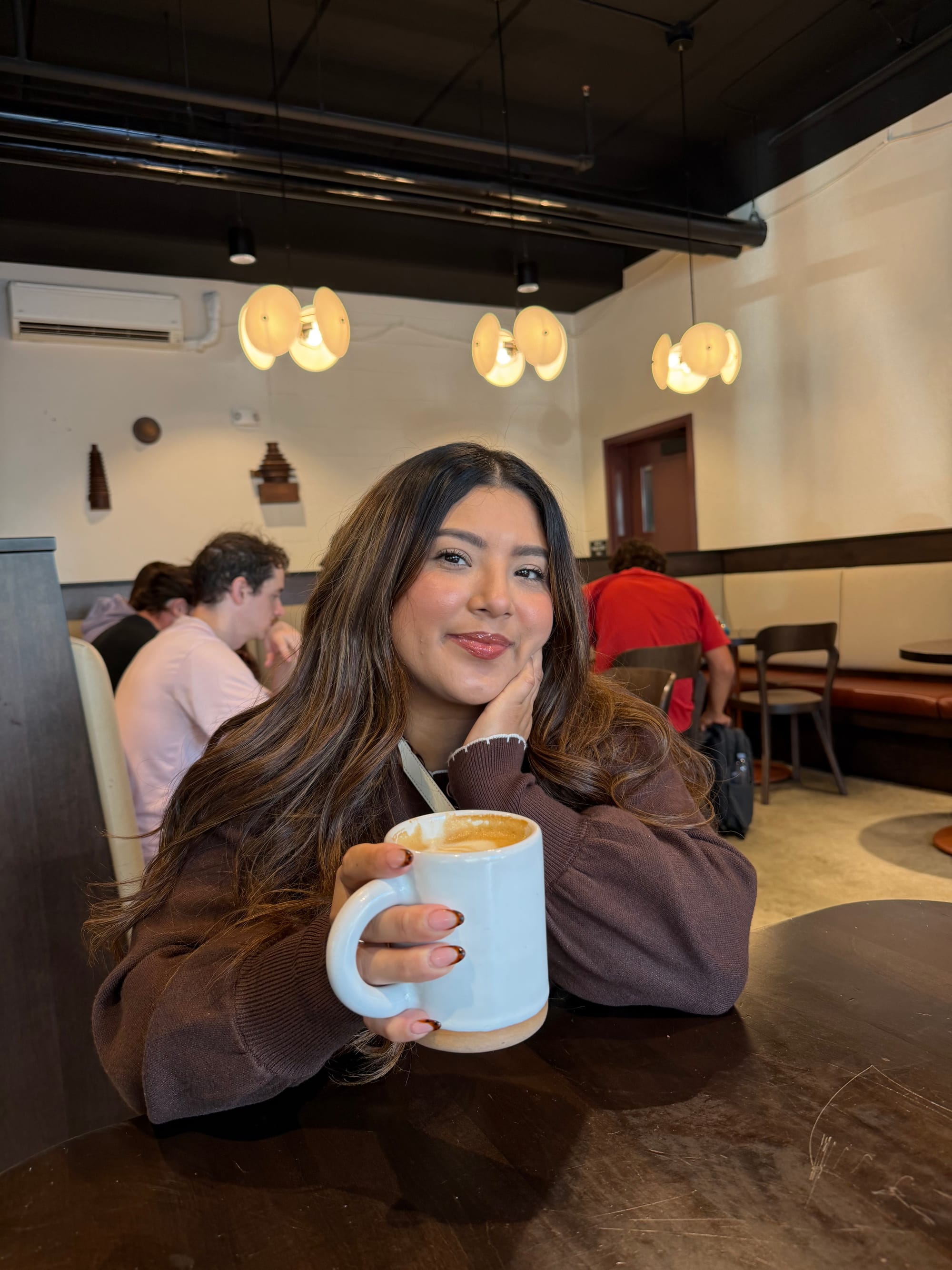 Erika, a wheelchair user, enjoying a late at Factory Coffee in Downtown Kalamazoo