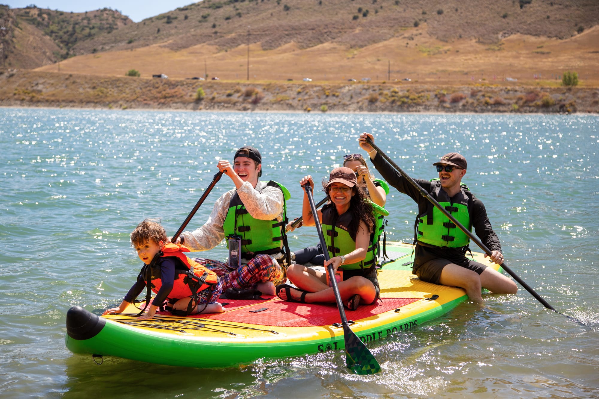 People with disabilities on a paddleboard with National Sports Center for the Disabled