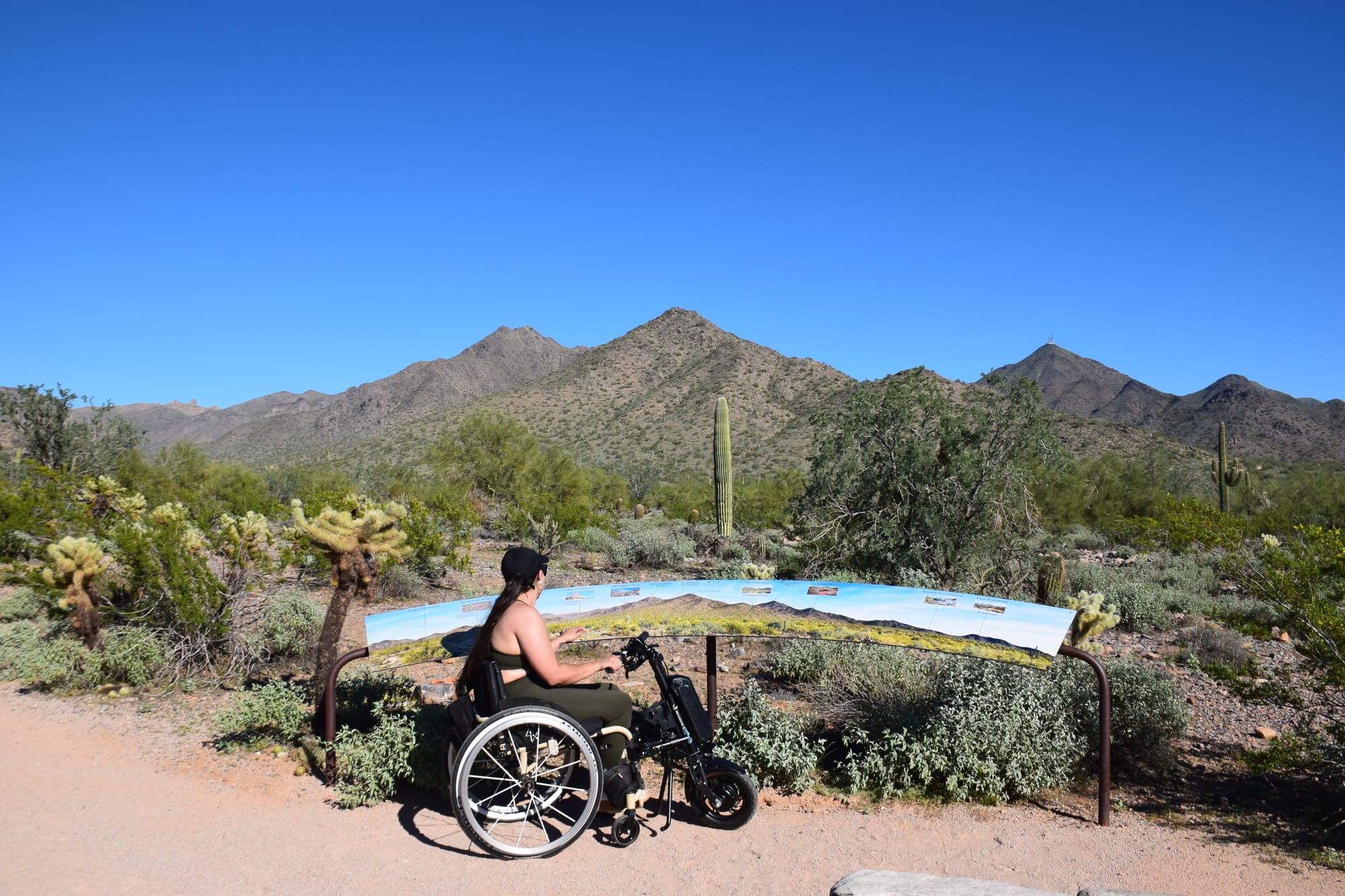 Kerry, manual wheelchair user, reading interpretive signs on Bajada Nature Trail near Scottsdale