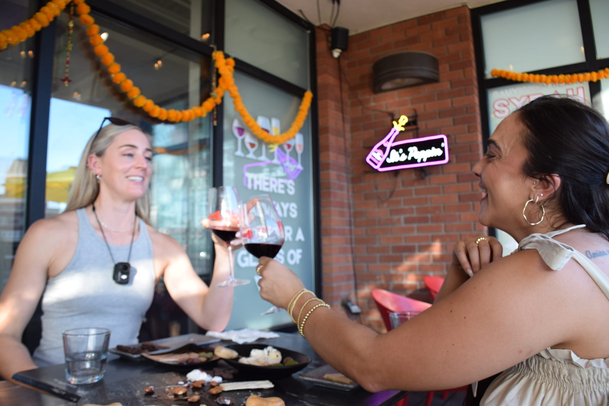 Two friends cheering wine glasses with charcuterie and food