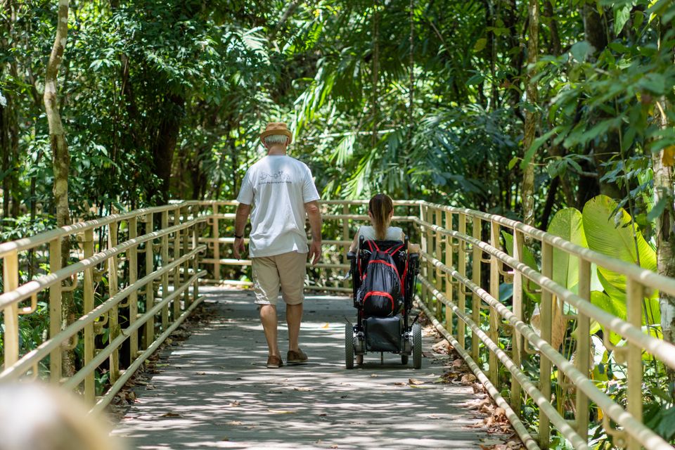 Wheelchair user and companion on accessible paths in Costa Rica