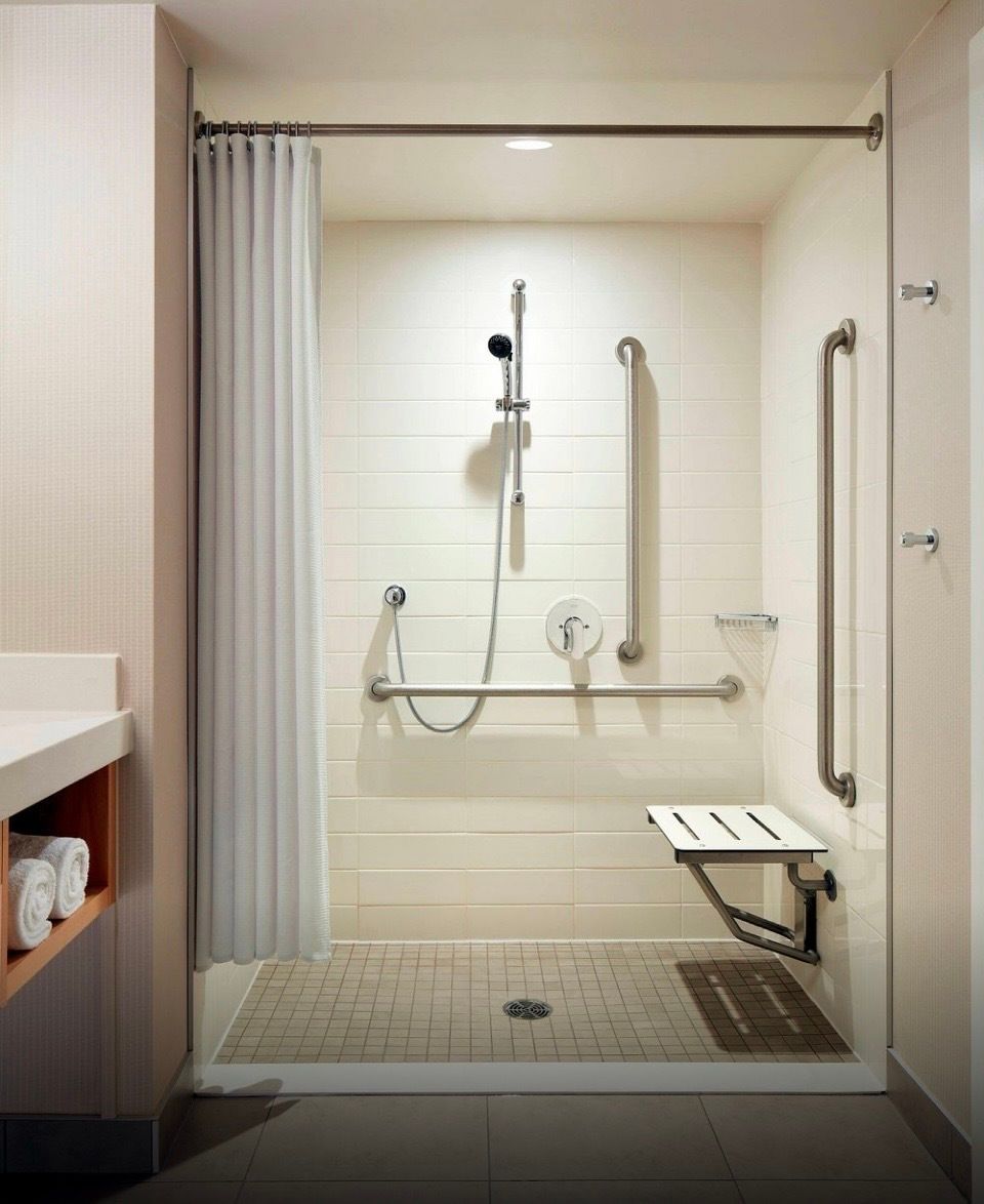 Roll-in showers have no threshold, or very low thresholds, with a shower seat and grab bars.