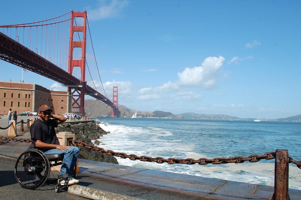 Wheelchair-user in San Francisco with Golden Gate Bridge in the background