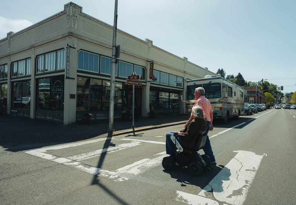 Wheelchair user and companion traveling in Astoria, Oregon