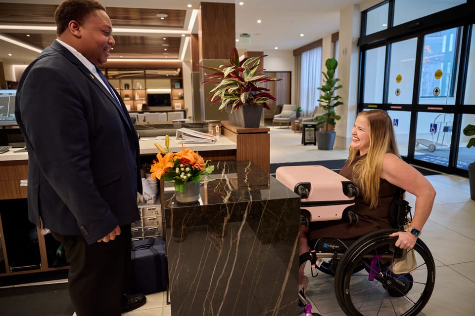 Wheelchair user checking into an accessible hotel in Lansing, Michigan