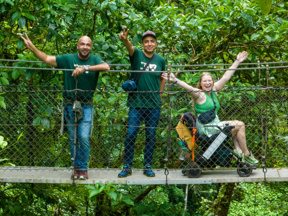 Wheelchair user and companions crossing accessible hanging bridges in Costa Rica