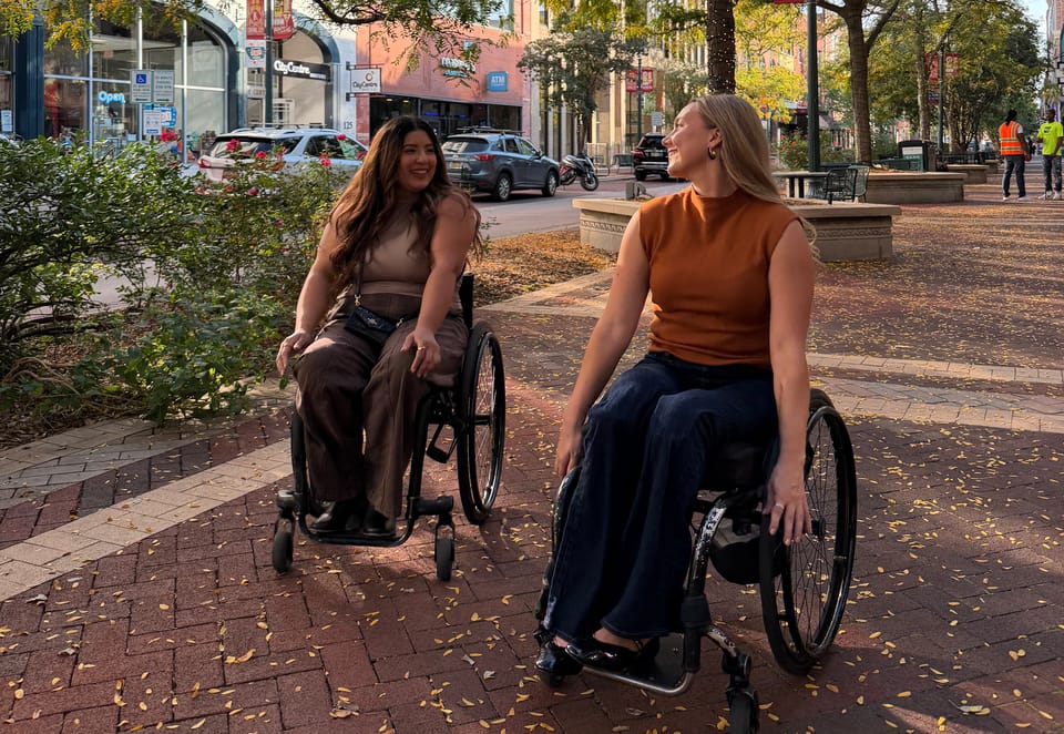 Two wheelchair users in downtown Kalamazoo, Michigan during fall
